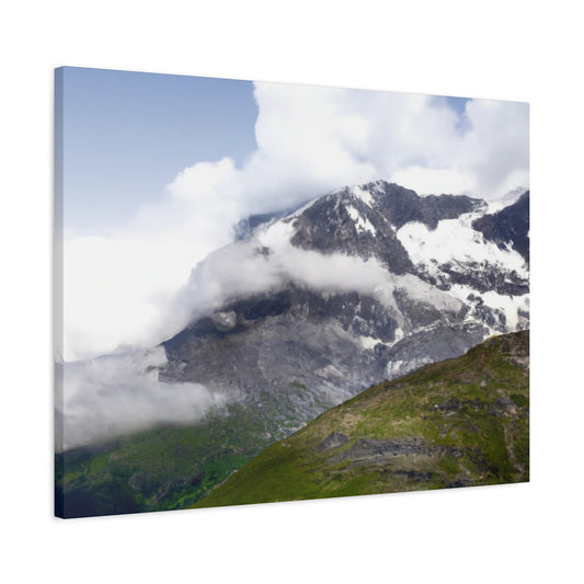 Canvas print showcasing a towering mountain peak surrounded by flowing white clouds. Comes with a frame made of ethically-sourced radial pine and back hanging for easy setup.